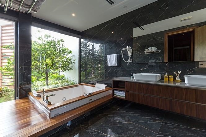 Phòng tắm cùng bồn ngâm cũng được thiết kế với đá phiến và cửa kính.