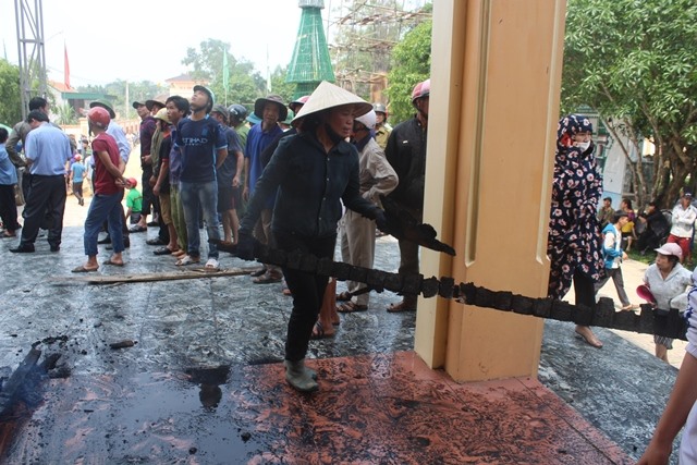 Người dân đưa những thanh gỗ đã cháy đen ra bên ngoài