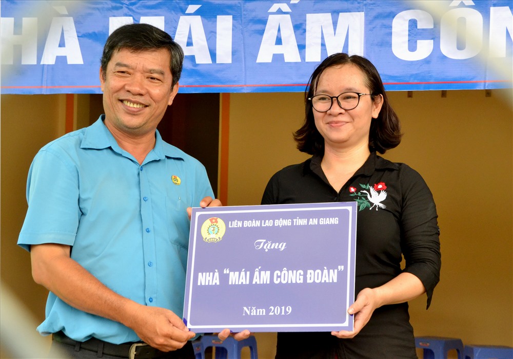Phó Chủ tịch LĐLĐ An Giang Nguyễn Hữu Giang trao bản tượng trưng MÂCĐ cho đoàn viên Lê Thị Hải Yến. Ảnh: Lục Tùng