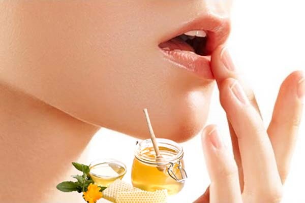 Sử dụng mật ong để chữa khô môi.