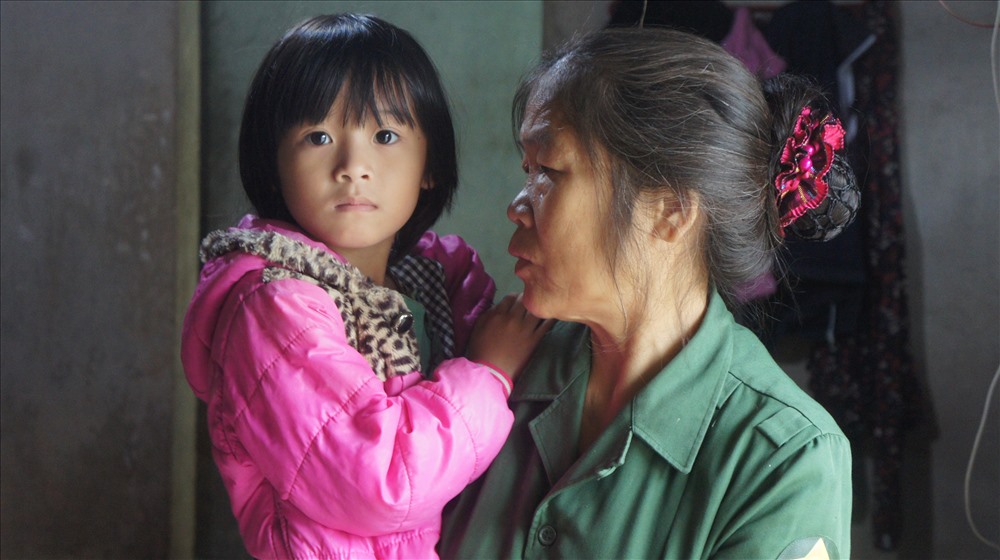 Bà Nguyễn Thị Tam bế cháu Lê Nguyễn Thanh Ngân con gái của nạn nhân.