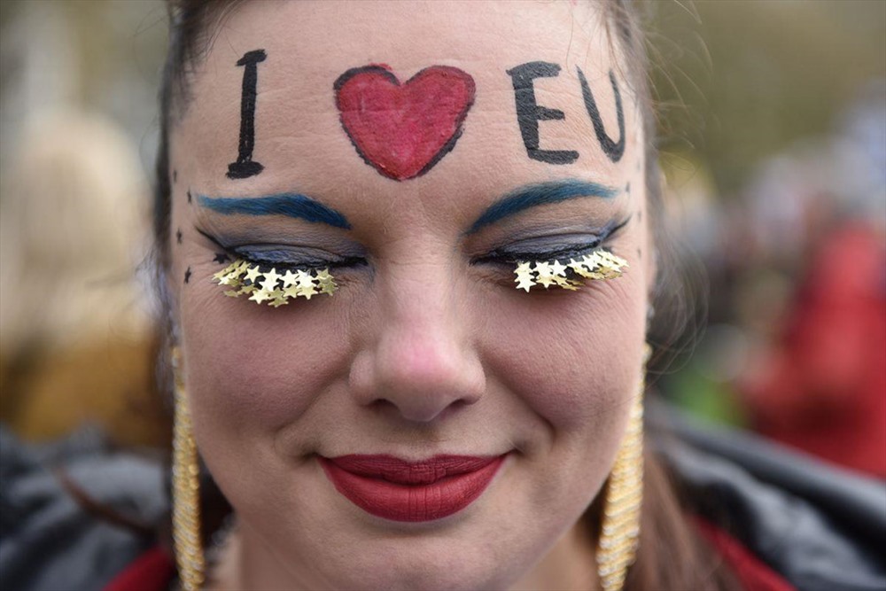 Một người phụ nữ vẽ lên khuôn mặt của mình dòng chữ “I love EU“.