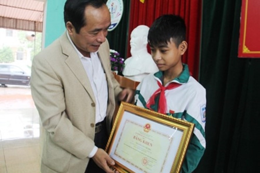 Giám đốc Sở GDĐT Hà Tĩnh Trần Trung Dũng tặng Bằng khen cho em Nguyễn Văn Chương. Ảnh: GDTĐ