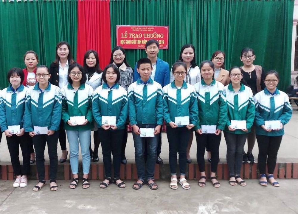 Như Hà (đứng thứ 4 từ trái sang) trong lễ trao thưởng học sinh giỏi của trường nơi em đang theo học