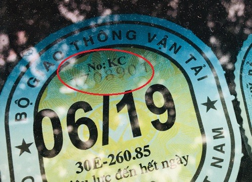 Tem đăng kiểm dán trên kính xe.