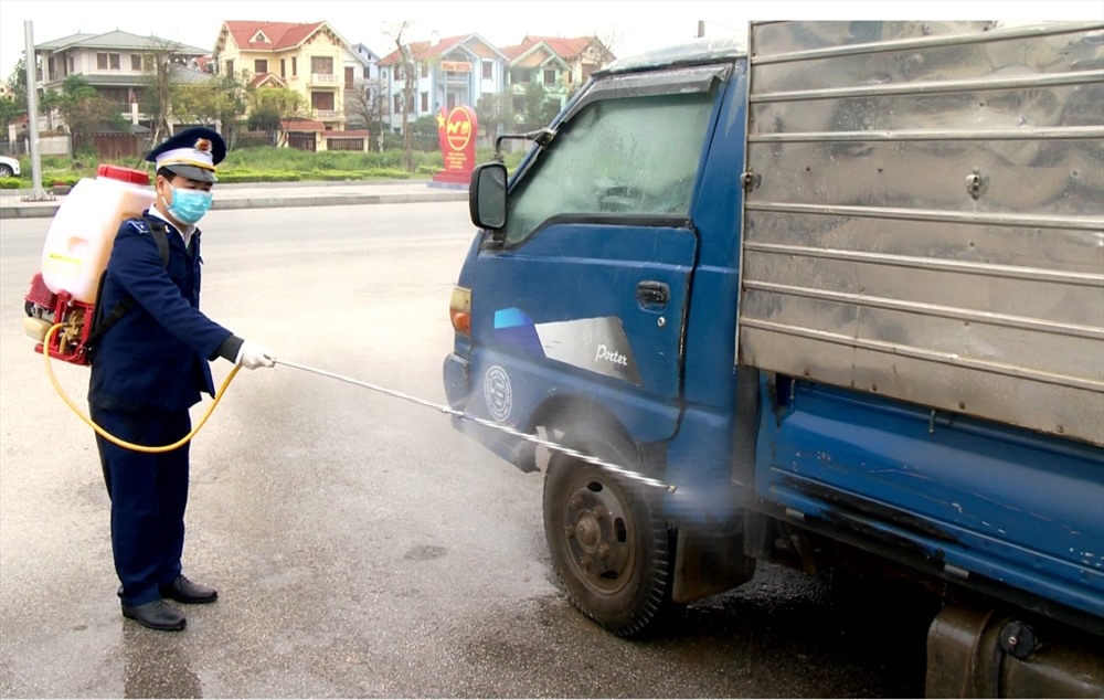 Lực lượng chức năng tiến hành tiêu độc, khử trùng các phương tiện ra vào vùng có dịch để ngăn chặn dịch lây lan. Ảnh: NT