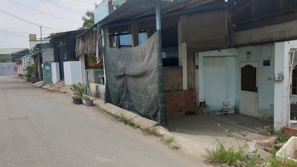 Người dân chắn bụi bằng tấm bạt lớn trước cửa nhà.