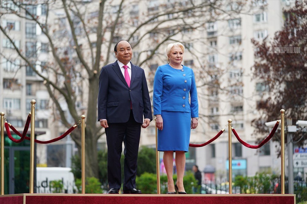 Thủ tướng Nguyễn Xuân Phúc và Thủ tướng Viorica Dancila thực hiện nghi lễ chào cờ hai nước tại lễ đón. Ảnh: VGP/Quang Hiếu