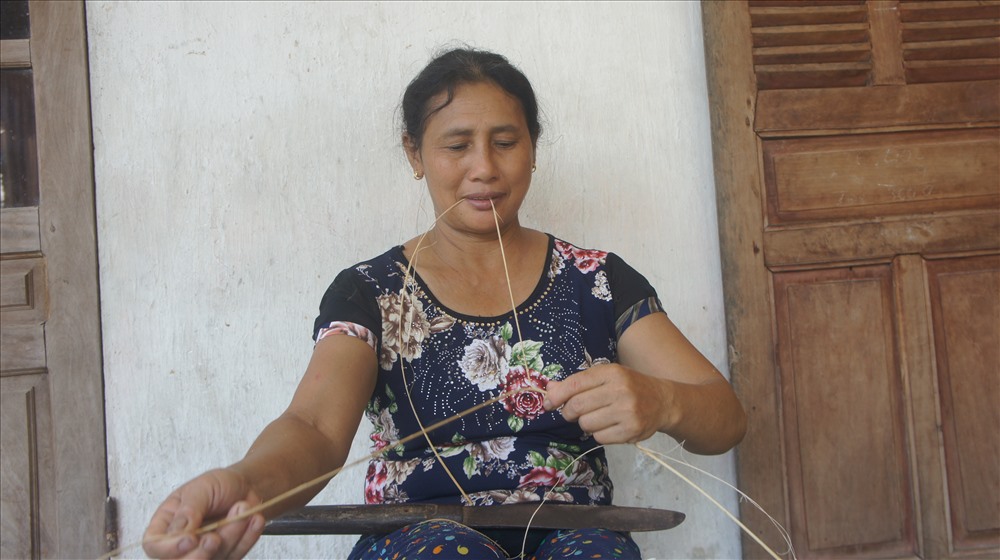Chị Nguyễn Thị Sỵ vừa chẻ mây vừa trò chuyện