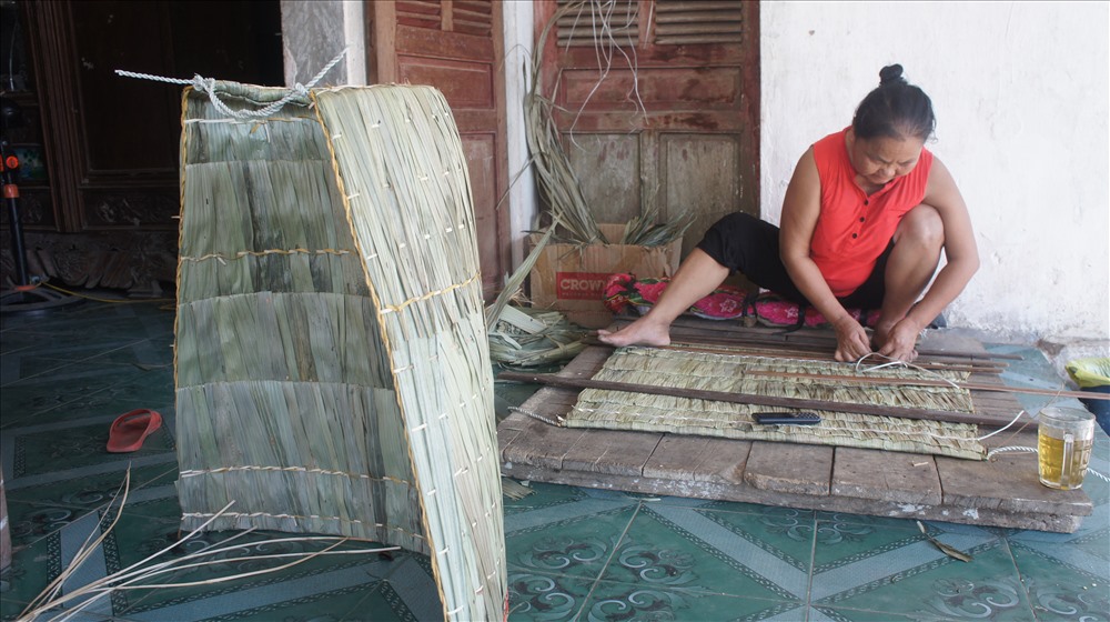 Bà Nguyễn Thị Thái vừa chằm tơi vừa trò chuyện