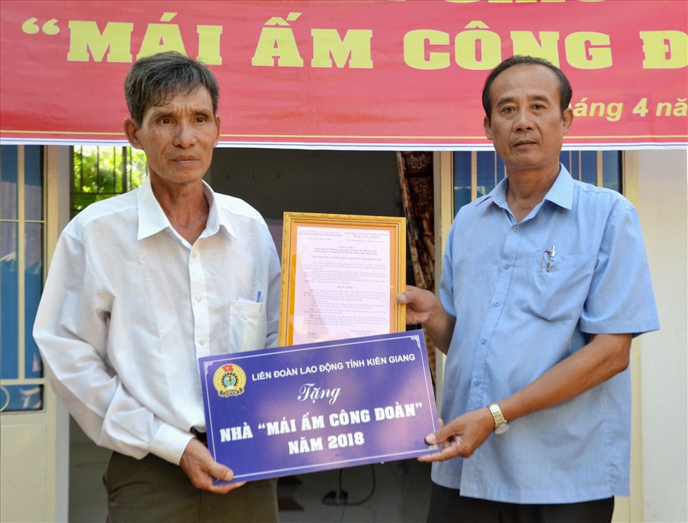 Phó Chủ tịch LĐLĐ Kiên Giang Nguyễn Minh Dũng (phải) trao quyết định MÂCĐ cho đoàn viên Trần Vũ Tuấn. Ảnh: Lục Tùng