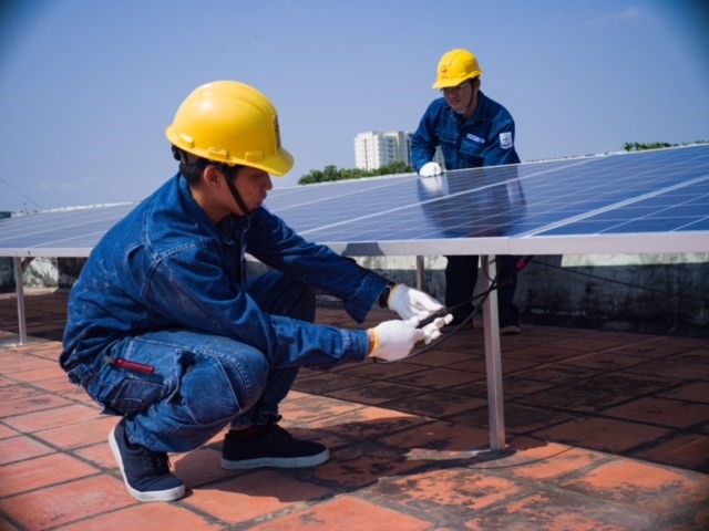 Công nhân của EVNHCMC lắp đặt hệ thống điện mặt trời áp mái cho một hộ dân trên địa bàn TPHCM.