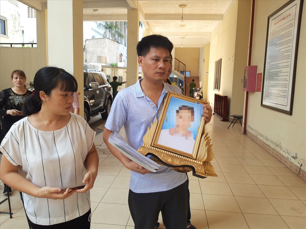 Gia đình bị hại ôm theo di ảnh của con đến tòa án.