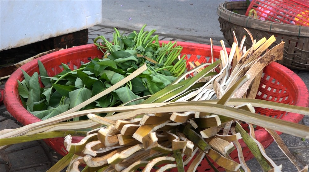 Bó rau muống cùng mo cau chẻ sợi của bà Mười khi bán ở vỉa hè. Ảnh: Đ.V