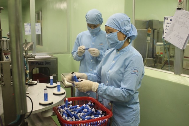 Chị Lan Anh (bên phải) trong giờ làm việc tại dây chuyền sản xuất kem mỡ của Cty CP Dược Hà Tĩnh. Ảnh: Trần Tuấn