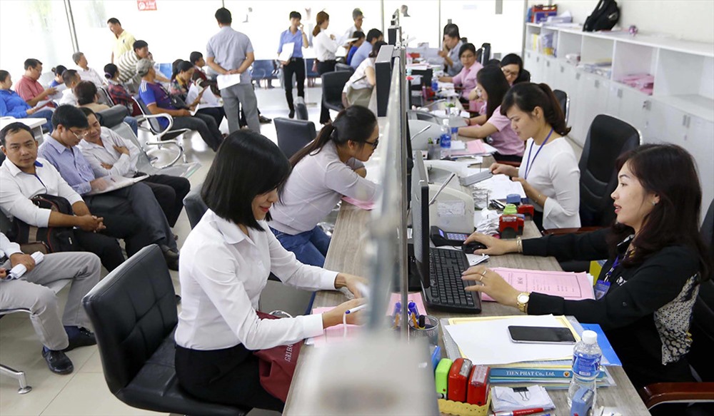 Chị Nguyễn Thị Hồng Minh tiếp nhận hồ sơ tại bộ phận Một cửa phường Thanh Nhàn (quận Hai Bà Trưng). Ảnh PV.