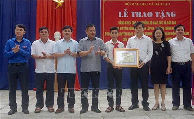 Đại diện Bộ giáo dục và đào tạo trao Bằng khen cho nam sinh cứu sống 3 em nhỏ bị đuối nước. Ảnh: TTXVN phát
