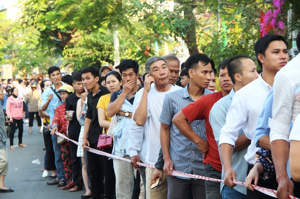 Dòng người xếp hàng dài trên đường Phan Đình Phùng chờ lấy phiếu đăng ký tiêm chủng.