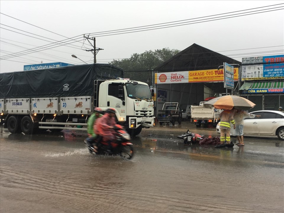 Người đàn ông bị tai nạn tử vong dưới trời mưa bão, người dân mang ô ra che thi thể. Người đàn ông bị tai nạn tử vong dưới trời mưa bão, người dân mang ô ra che thi thể.