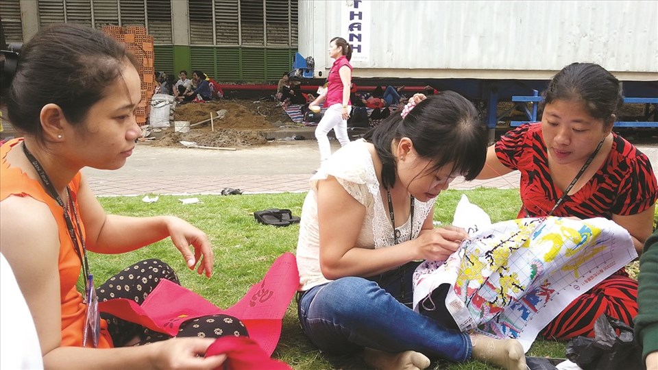 Chị em công nhân tranh thủ giờ nghỉ trưa thêu tranh để làm quà Tết cho gia đình - Ảnh: L.T Chị em công nhân tranh thủ giờ nghỉ trưa thêu tranh để làm quà Tết cho gia đình - Ảnh: L.T