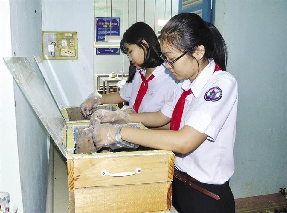 Hai em Trần Hoàng Mai (đeo kính) và Thái Mỹ Huyền tranh thủ đi học sớm và giờ ra chơi để vào phòng thí nghiệm chăm sóc những con sâu. Ảnh: CHÂU TƯỜNG Hai em Trần Hoàng Mai (đeo kính) và Thái Mỹ Huyền tranh thủ đi học sớm và giờ ra chơi để vào phòng thí nghiệm chăm sóc những con sâu. Ảnh: CHÂU TƯỜNG