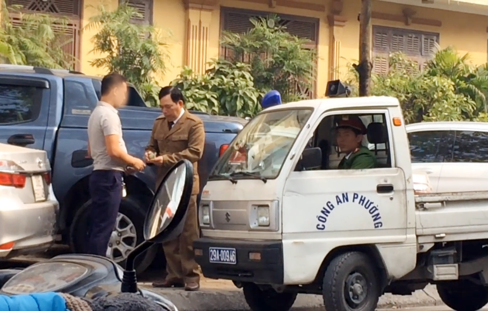 Bảo vệ đang thu tiền gửi xe của người dân. Ảnh: MT.