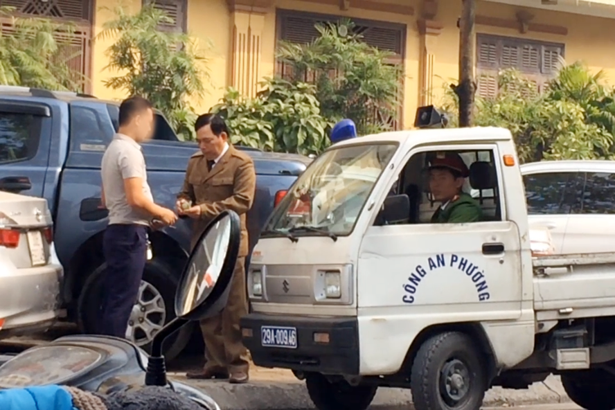 Bảo vệ đang thu tiền gửi xe của người dân. Ảnh: MT.