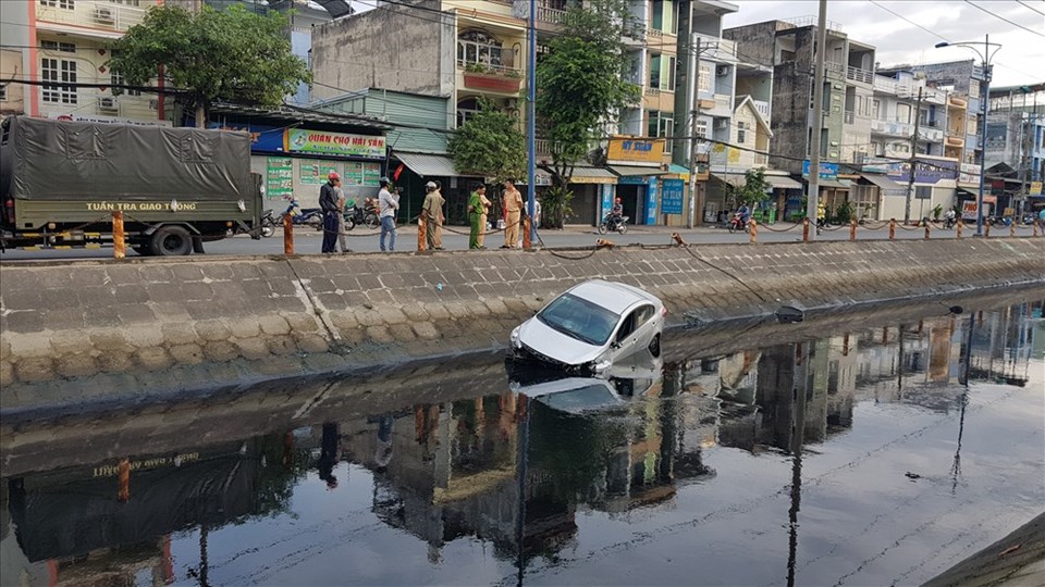Cảnh sát xử lý hiện trường vụ xe 4 chỗ lao xuống kênh nước đen trên đường Trần Văn Giàu vào sáng nay. Ảnh: T.S Cảnh sát xử lý hiện trường vụ xe 4 chỗ lao xuống kênh nước đen trên đường Trần Văn Giàu vào sáng nay. Ảnh: T.S