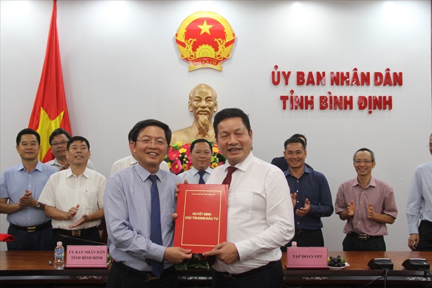 Chủ tịch UBND tỉnh Bình Định (bên trái) trao quyết định chấp thuận chủ trương đầu tư Tổ hợp giáo dục - trí tuệ nhân tạo cho Công ty cổ phần FBT.