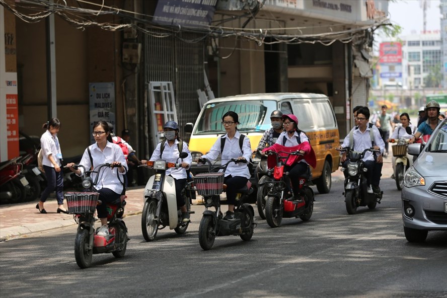 Nhiều học sinh điều khiển xe máy, xe đạp điện không đội mũ bảo hiểm khi tham gia giao thông. Ảnh: HẢI NGUYỄN