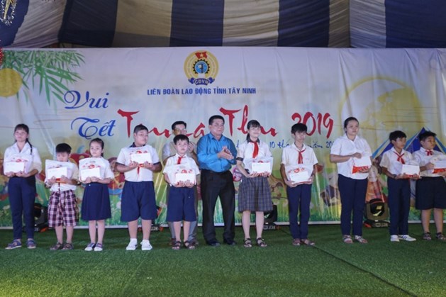 Lãnh đạo Ban Dân vận Tỉnh ủy và LĐLĐ tỉnh Tây Ninh trao tặng học bổng cho các em học sinh. Ảnh: PV