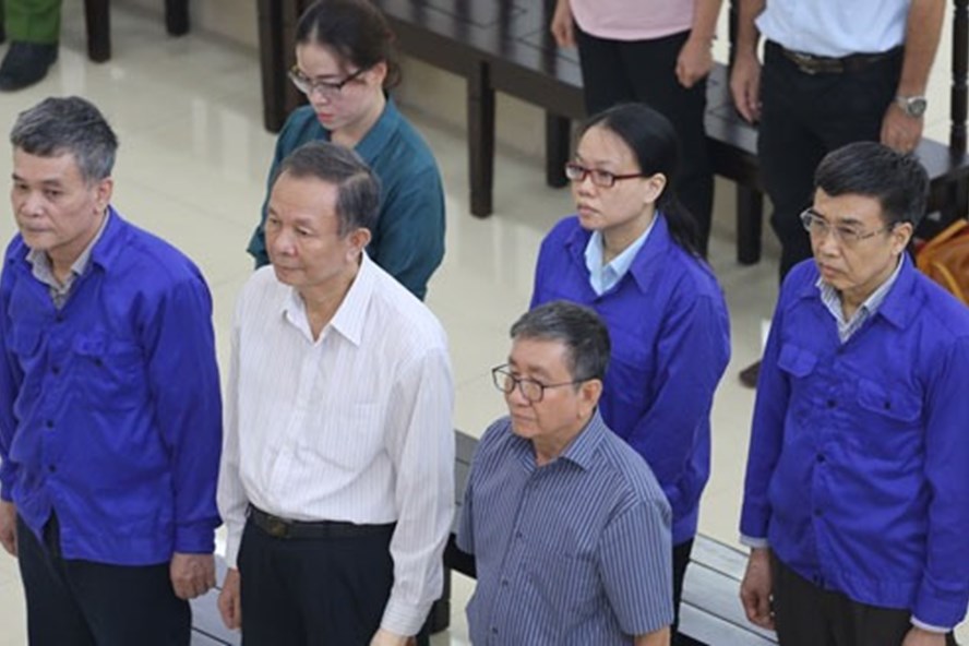 Bị cáo Nguyễn Huy Ban (áo trắng, hàng đầu), Lê Bạch Hồng (áo xanh, ngoài cùng bên phải) và nhóm cựu cán bộ BHXH VN nghe tòa tuyên án.